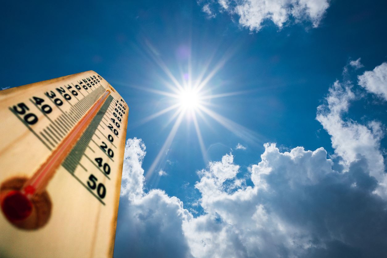 Thermometer pointing up toward the sun with minimal surrounding clouds